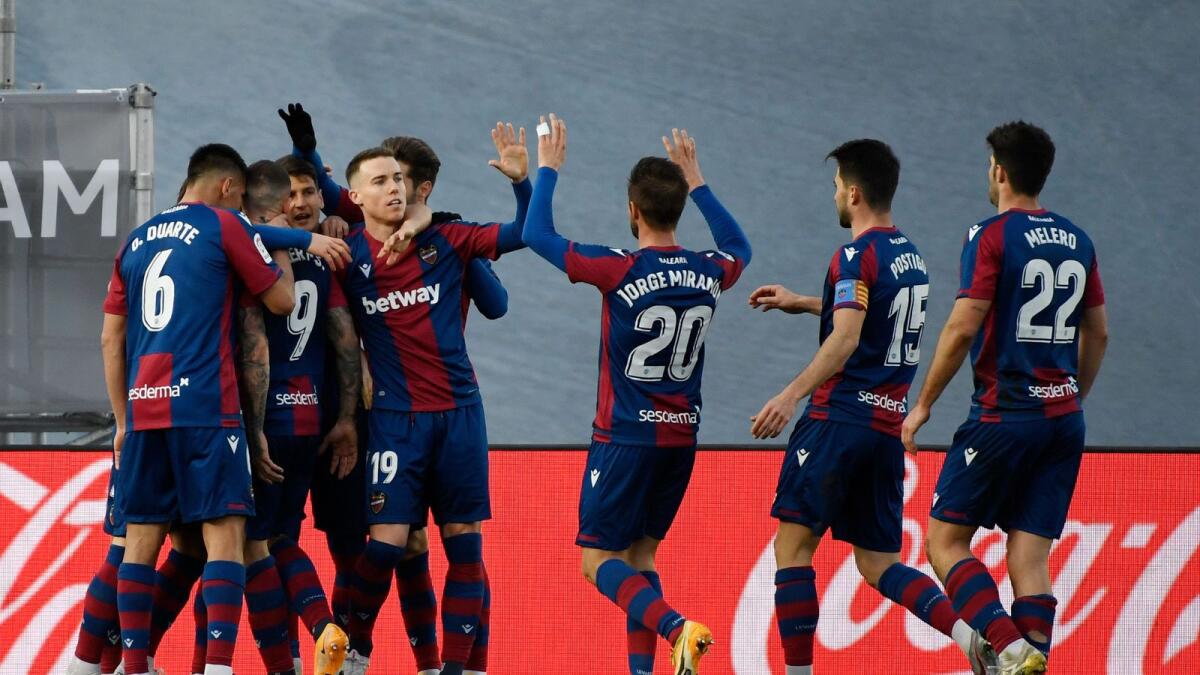 Levante's Spanish forward Roger Marti (second left) is congratulated by his teammates after he scored a goal against Real Madrid. — AFP