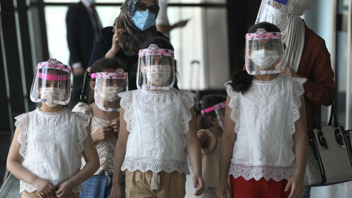 An Iraqi family wearing protective masks walk at the departure hall of Baghdad international airport following its reopening on July 23, 2020, after a closure forced by the coronavirus pandemic restrictions aimed at preventing the spread of the deadly Covid-19 illness in Iraq. Photo: AFP