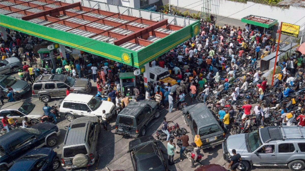 Drivers wait in hopes of filling their tanks at one of the few remaining open gas stations in Port-au-Prince, Haiti. — AP