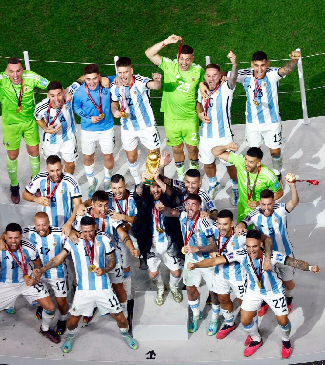 Argentina's Lionel Messi lifts the World Cup trophy alongside teammates. — Reuters