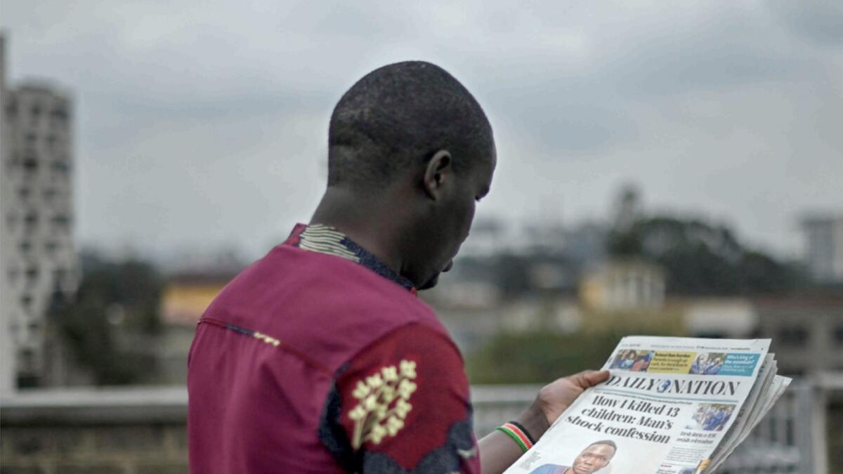 A man looks at the headlines of Kenya's newspaper Daily Nation which carries the story on a murderer involved in the deaths of at least 10 children in Nairobi. — AFP