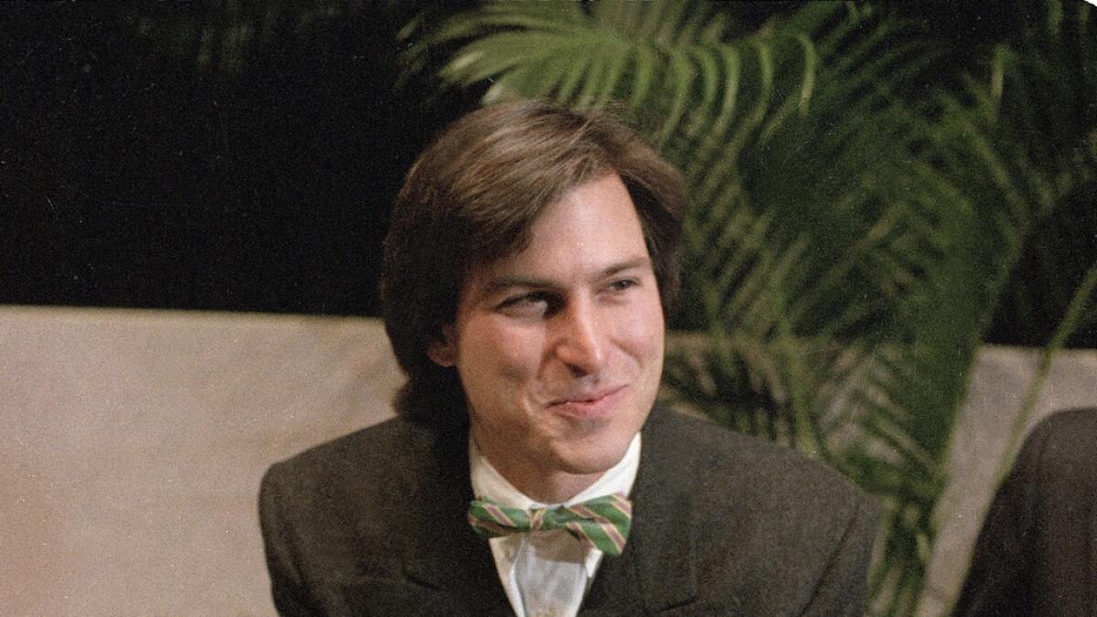 Steven Jobs, then chairman of the board of Apple Computer, leans on the new Macintosh personal computer following a shareholder's meeting in 1984. — AP file