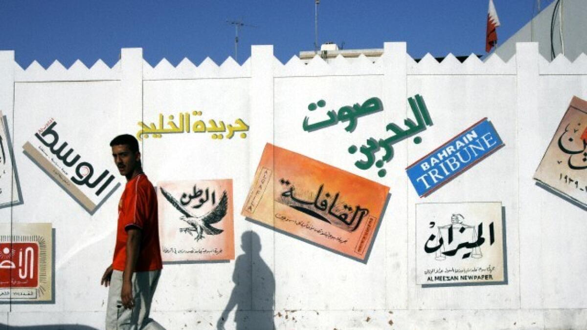 Bahraini newspaper logos painted onto a wall, Bahrain.