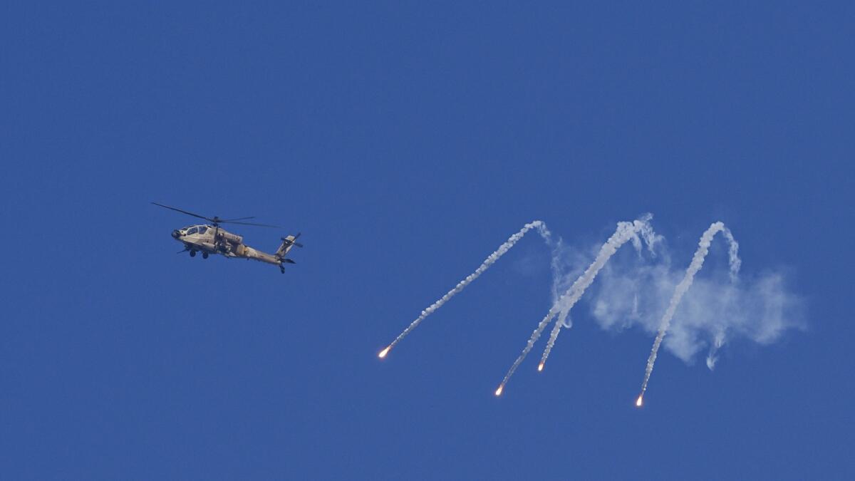 An Israeli military helicopter releases flares over the Israel-Gaza border as seen from southern Israel. - AP