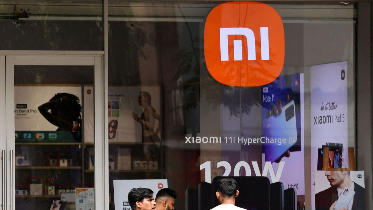 People walk past a Xiaomi store in Mumbai. Just 34 per cent of Xiaomi’s India unit sales this year have come from retail stores. — Reuters