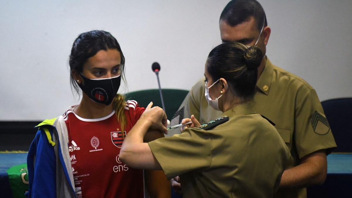 Brazilian freestyle swimmer Larissa Oliveira gets the Covid-19 vaccine on Friday as part of a project organised by the Brazilian government to vaccinate the country's athletes that will take part in the Tokyo Olympic Games. (AFP)