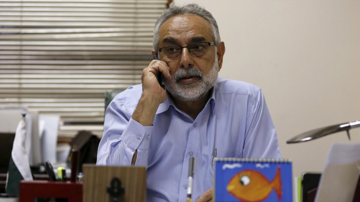 Zubair Habib, Chief of Citizen Police Liaison Committee, talks on mobile phone at his office in Karachi. — Reuters