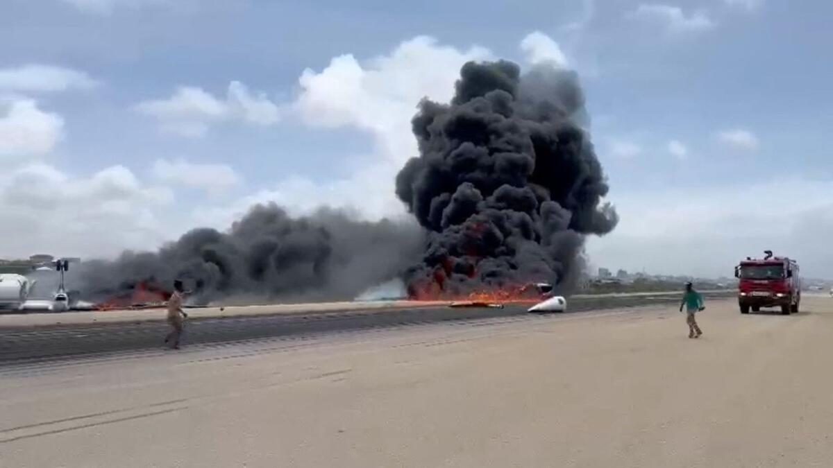 Smoke billows from a plane that flipped over after a crash landing, in Mogadishu, Somali. Photo: Reuters