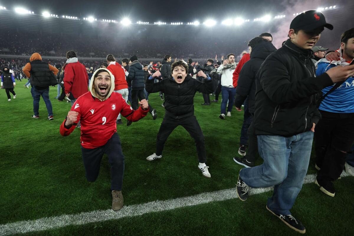 Georgia fans invade the pitch after their team won the Euro 2024 qualifying playoff final against Greece in Tbilisi. — AFP