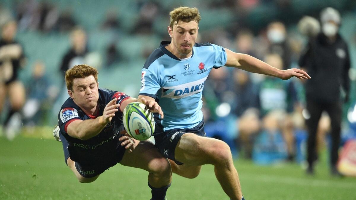 Waratahs player James Ramm (right) and Melbourne Rebels player Andrew Kellaway (left) fight for the ball during the Super Rugby match between Australia's Waratahs and Melbourne Rebels in Sydney
