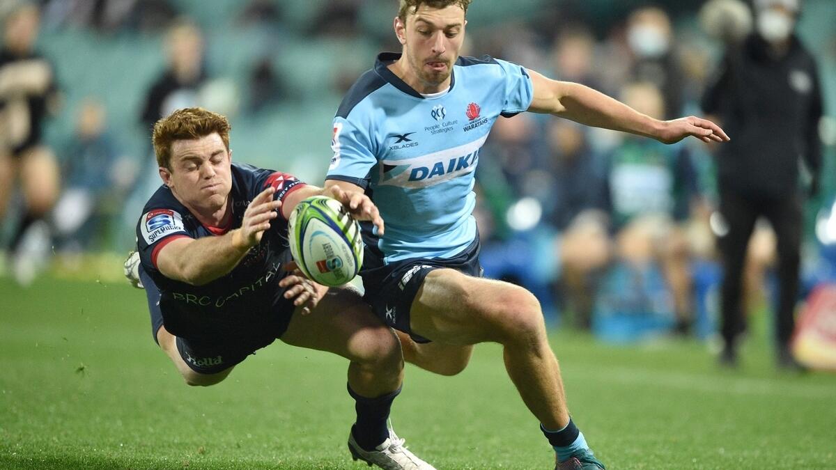 Waratahs player James Ramm (right) and Melbourne Rebels player Andrew Kellaway (left) fight for the ball during the Super Rugby match between Australia's Waratahs and Melbourne Rebels in Sydney