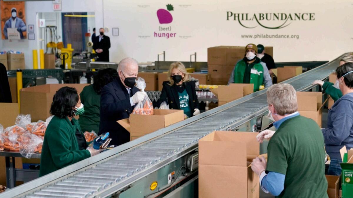 President Joe Biden and first lady Jill Biden pack produce while volunteering at hunger relief organisation Philabundance. — AP