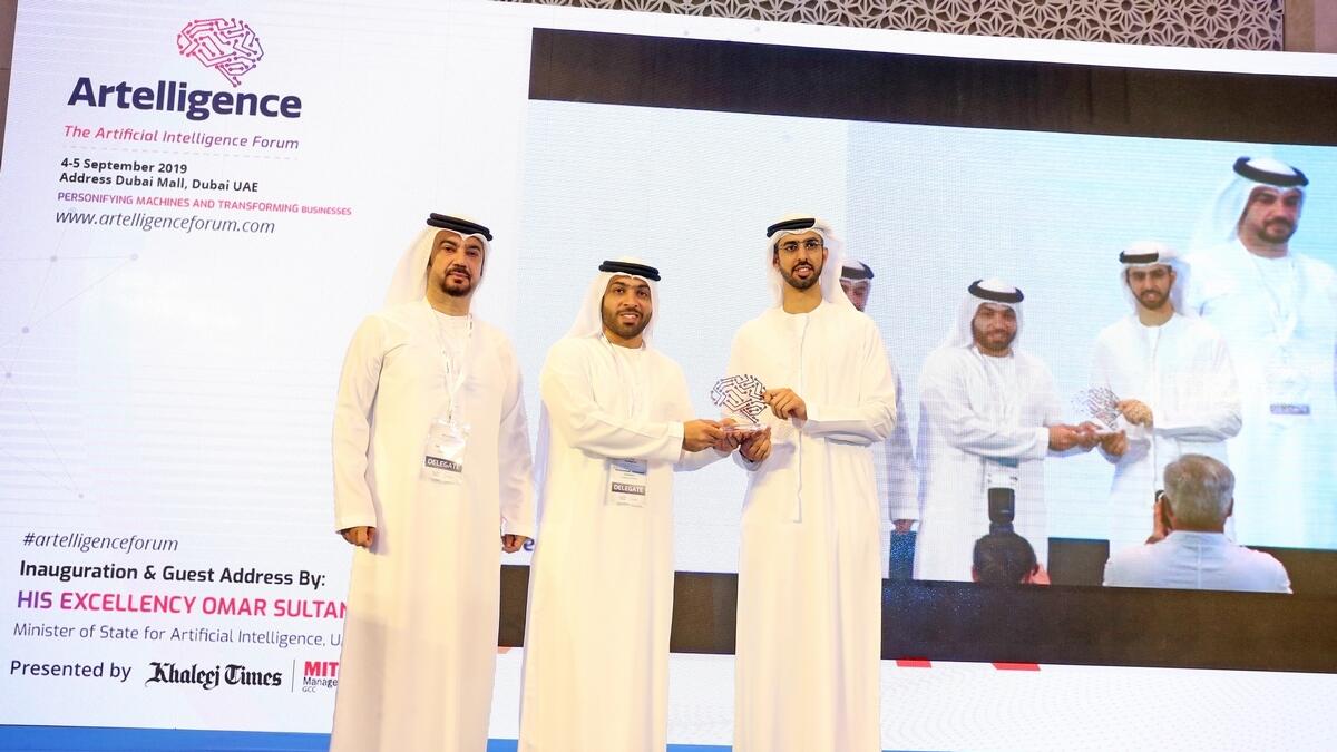 Omar bin Sultan Al Olama, UAE Minister of State for Artificial Intelligence, being presented with a memento by Mohammad Galadari, Executive Committee member and Director, Galadari Brothers; Hesham Khoory, Director, Galadari Brothers, at Artelligence in Dubai on Wednesday.