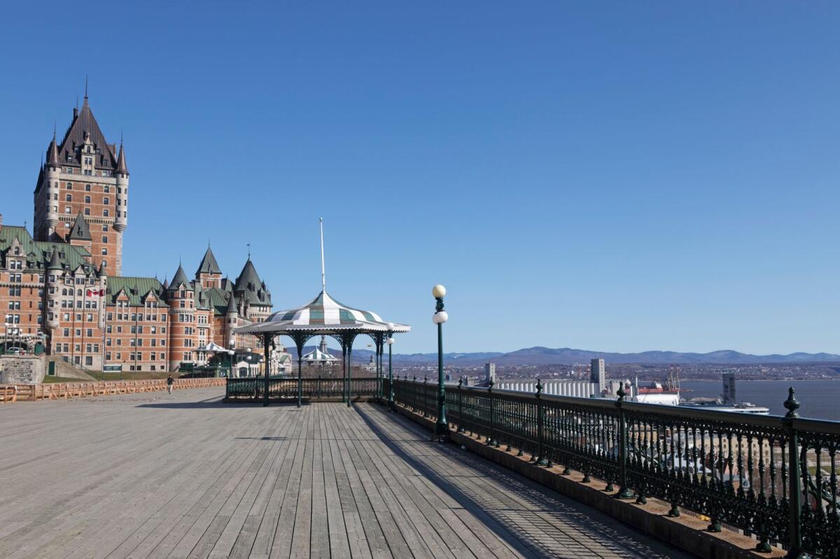 Dufferin Terrace in Quebec City, Canada. The Fairmont Le Château Frontenac hotel looks onto the wood promeanade with views over the Saint Lawrence River.