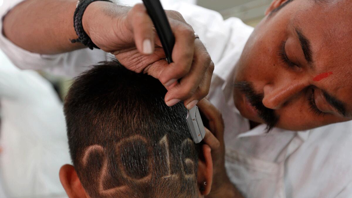 A man gets a haircut depicting 2016 to welcome the New Year at a barbershop in Ahmedabad, India.