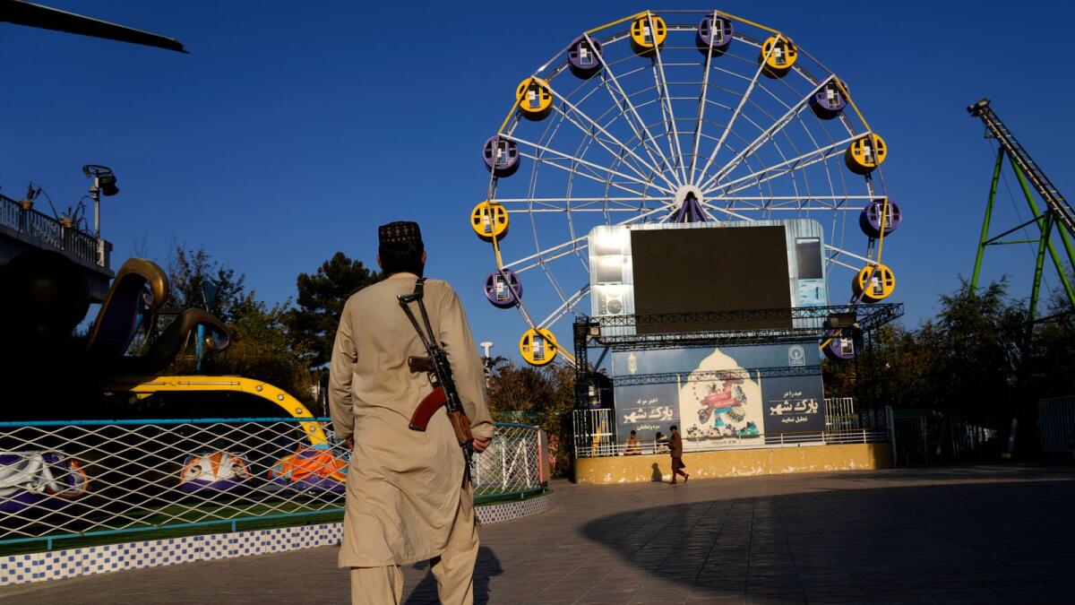 A Taliban fighter stands guard in an amusement park in Kabul, Afghanistan, on November 10, 2022.  The Taliban have banned women from using gyms and parks.— AP file