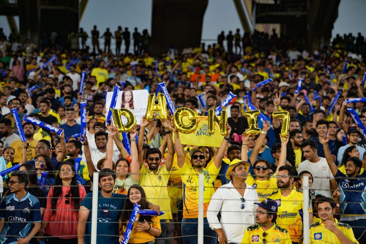 Mahendra Singh Dhoni's fans cheer at the Narendra Modi Stadium in Ahmedabad on Sunday. The final was postponed to Monday due to rain. — AFP