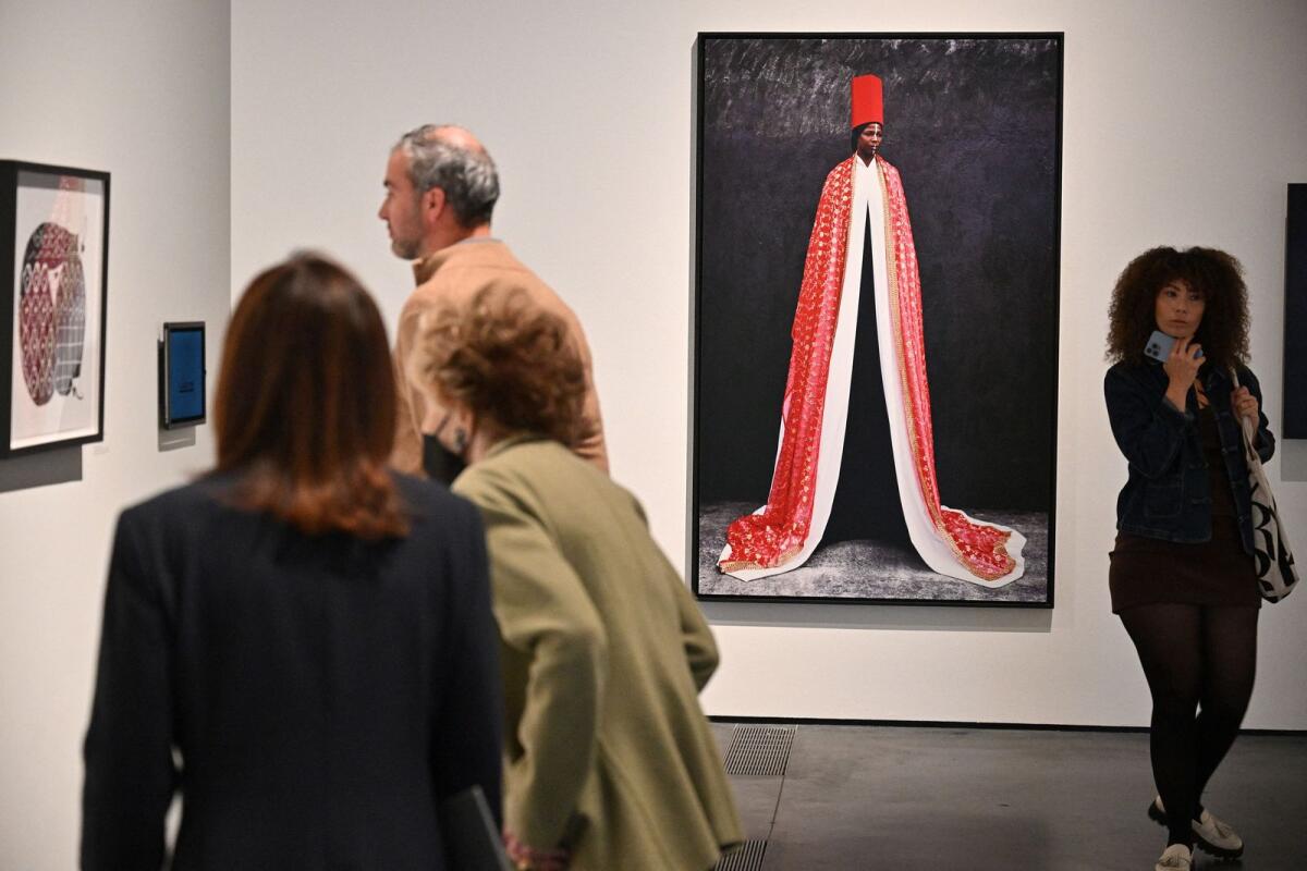 Visitors looks at works including “Rhokaya, 2010” a dye coupler print by Italian-born artist Maimouna Guerresi at the press preview for the exhibition “Women Defining Women in Contemporary Art of the Middle East and Beyond”  in Los Angeles, California. — AFP