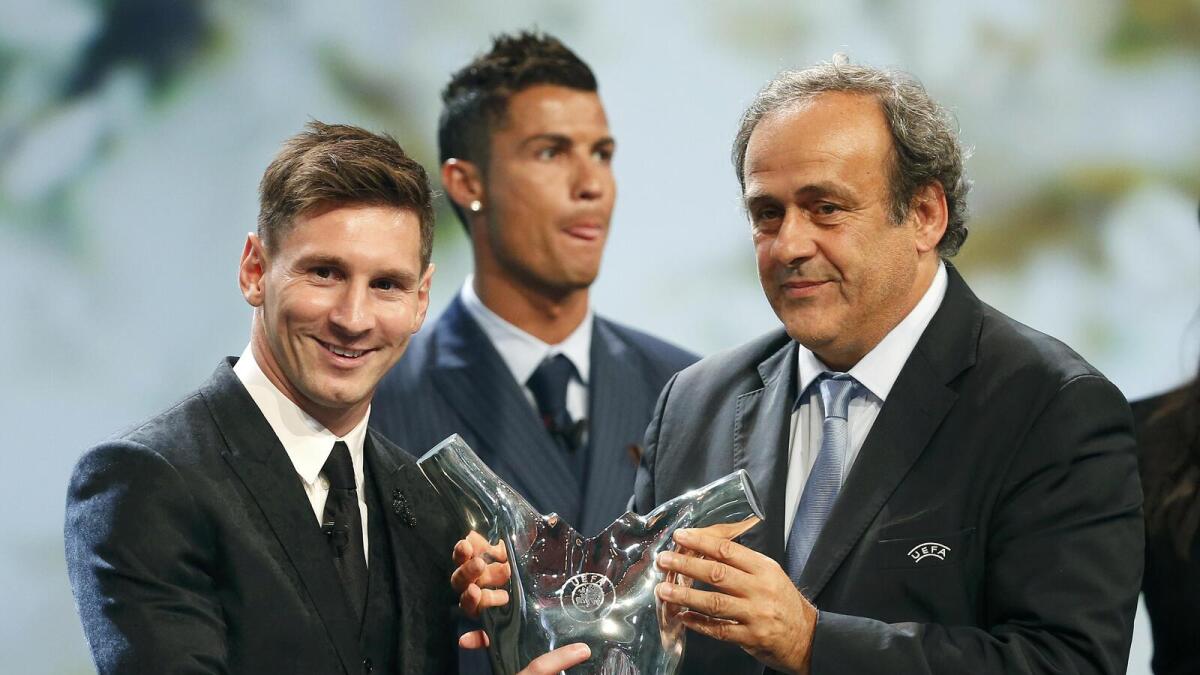 Lionel Messi (left) receives trophy from UEFA President Michel Platini. 