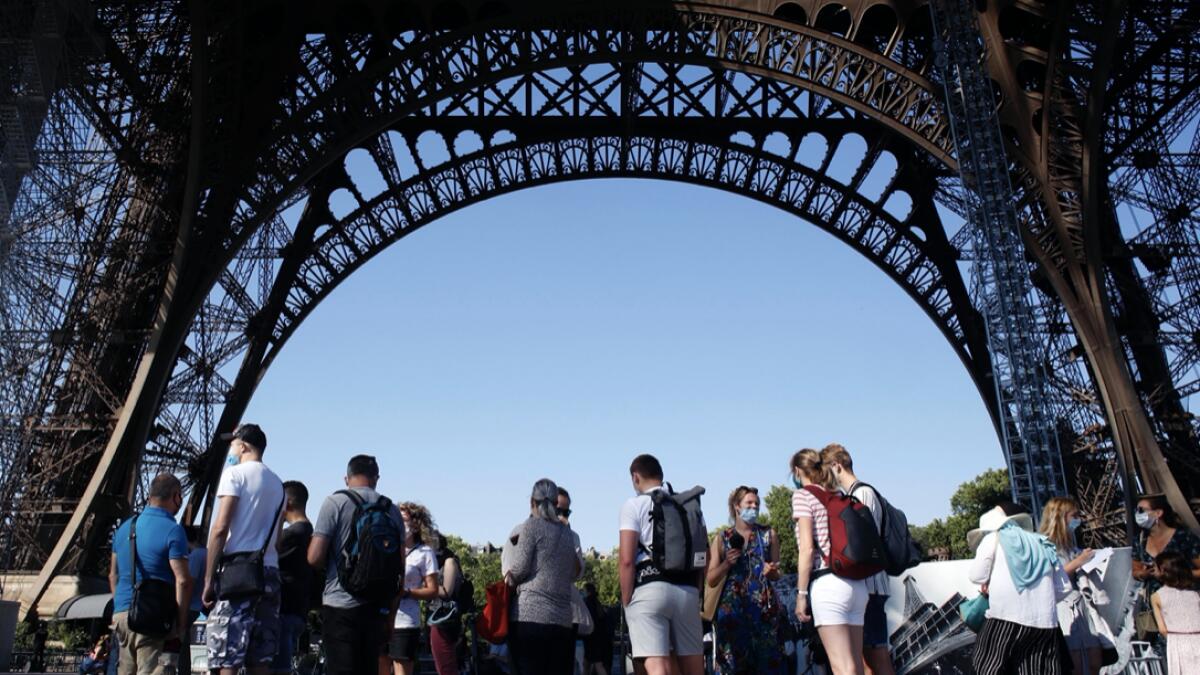 People queue up prior to visit the Eiffel Tower, in Paris. The Eiffel Tower reopens after the coronavirus pandemic led to the iconic Paris landmark's longest closure since World War II. Photo: AP