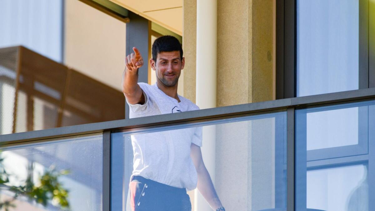 Novak Djokovic of Serbia gestures from his hotel balcony in Adelaide, one of the locations where players have quarantined for two weeks upon their arrival ahead of the Australian Open. — AFP