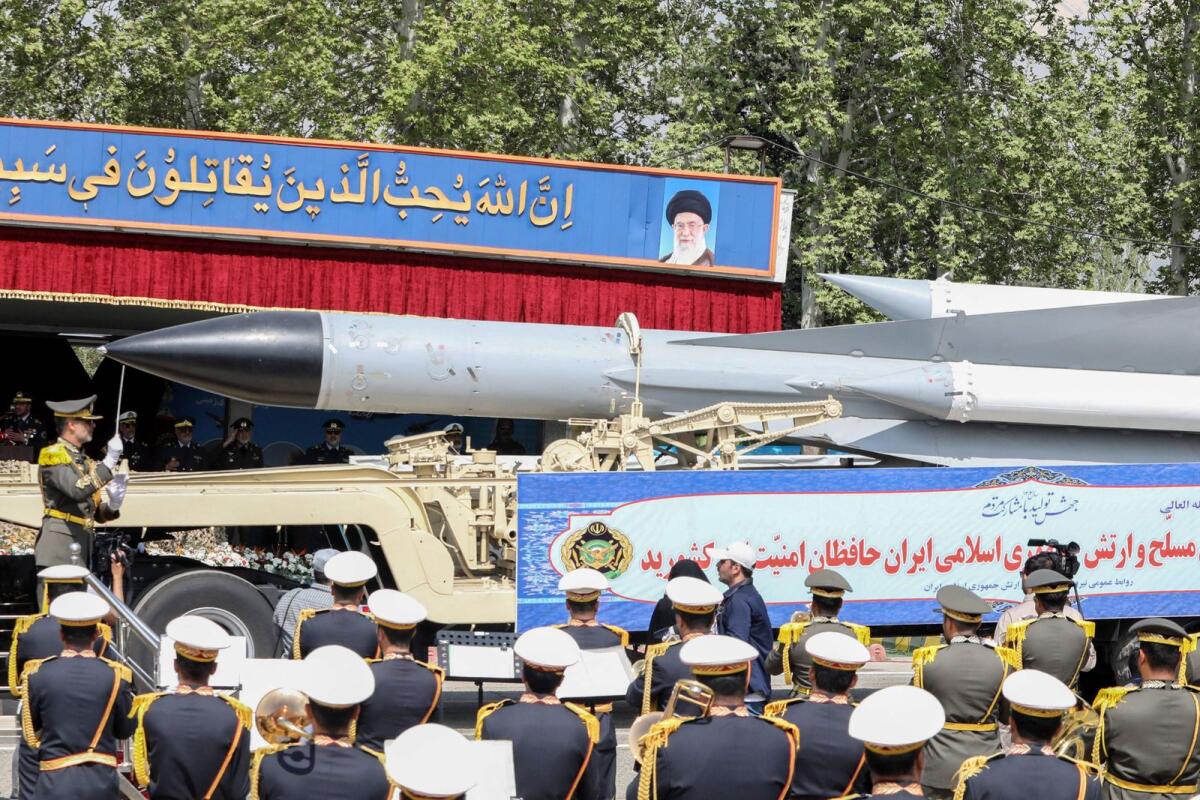 A member of the Iranian armed forces conducts an army orchestra as a truck carries a missile during a military parade as part of a ceremony marking the country's annual army day in the capital Tehran on Wenesday. — AFP