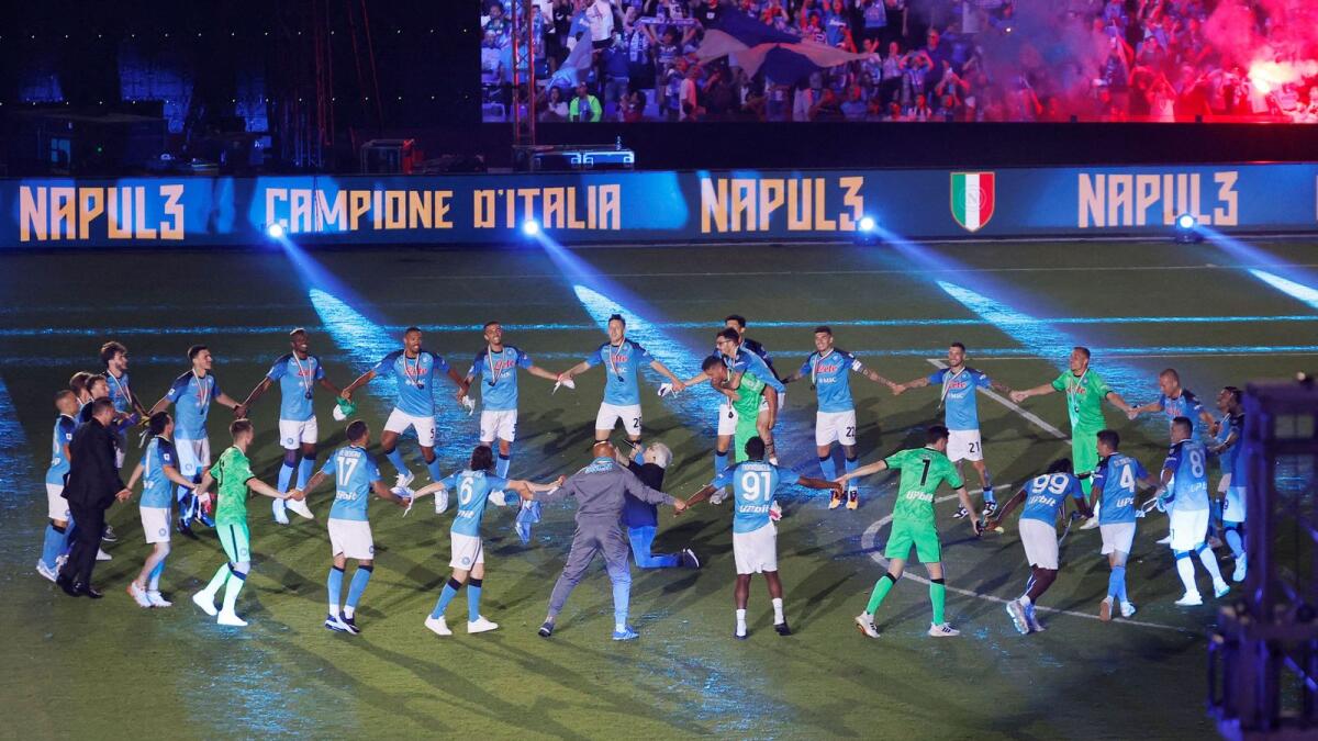 Napoli players celebrate on the pitch after winning Serie A. — Reuters