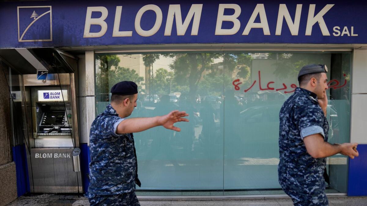Lebanese policemen pass next to a bank that was attacked by depositors, in Beirut, Lebanon. –AP