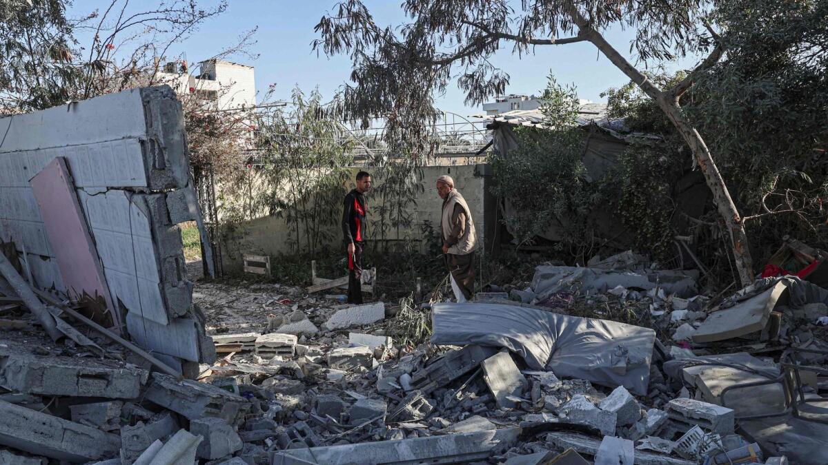 Palestinians search for their belongings amid the rubble of houses destroyed by Israeli bombardment in Rafah. — AFP