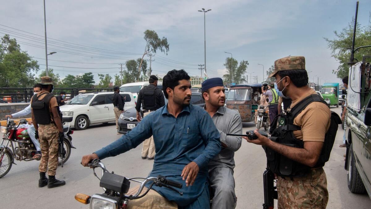 Army soldiers stop commuters at a road checkpoint in Peshawar. Photo: AFP