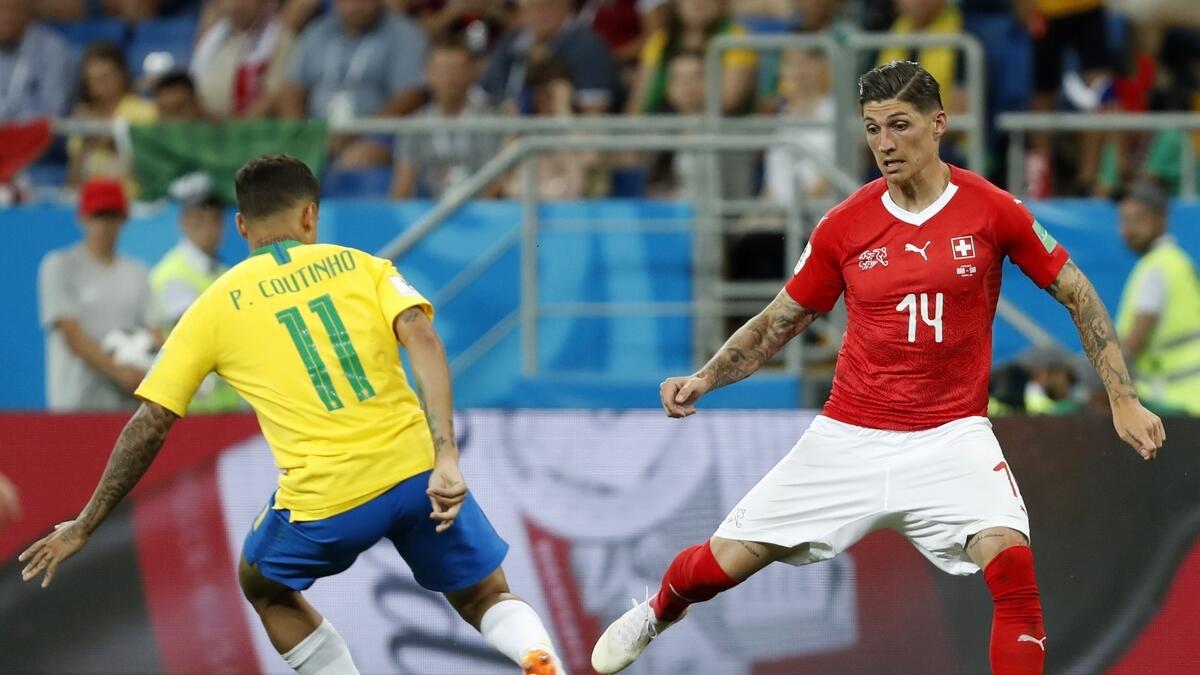 Switzerlands Steven Zuber, right, duels for the ball with Brazils Philippe Coutinho during the group E match between Brazil and Switzerland.-AP 