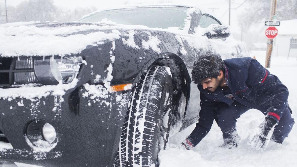 A man digs out his car after getting stuck in the snowing Bowling Green, Ky.-AP