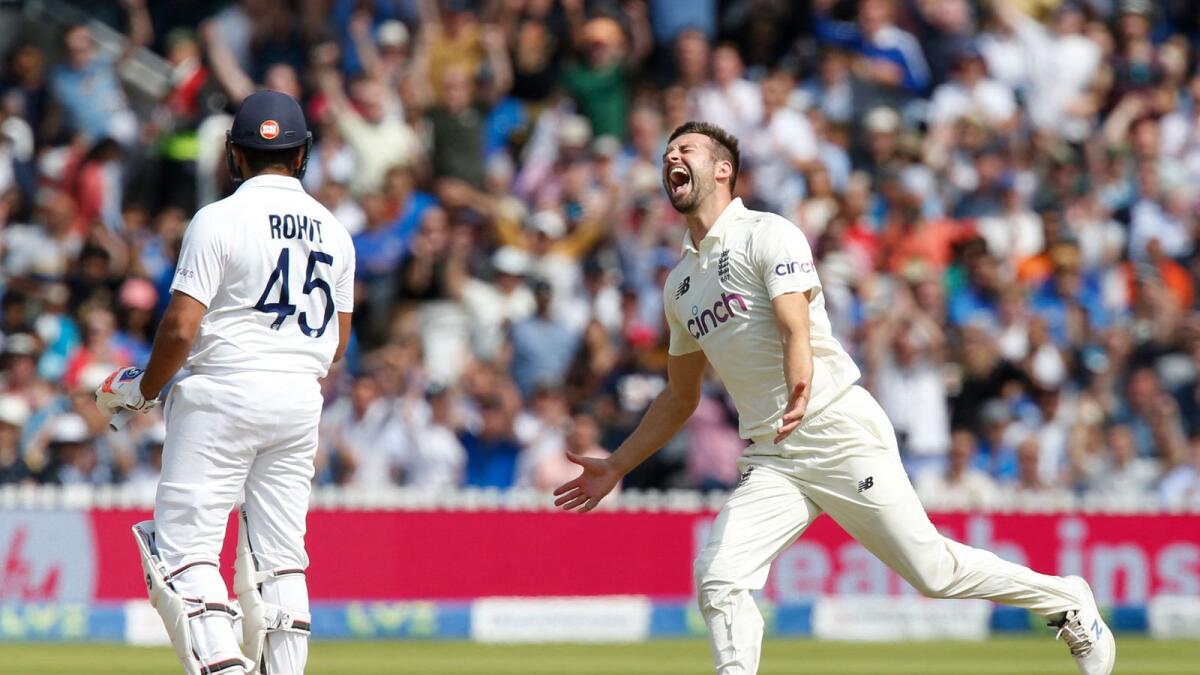 England's Mark Wood (right) celebrates after taking the wicket of India's Rohit Sharma for 21 runs on the fourth day of the second Test at Lord's. — AFP