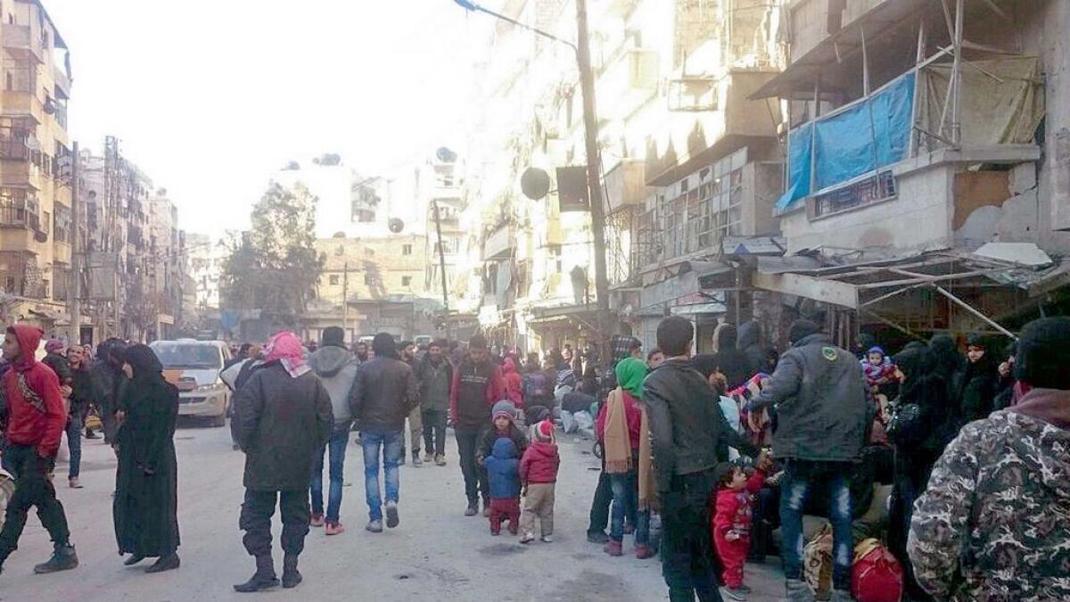 Eastern Aleppo residents wait in the streets to be evacuated from the war-torn city on Thursday. 