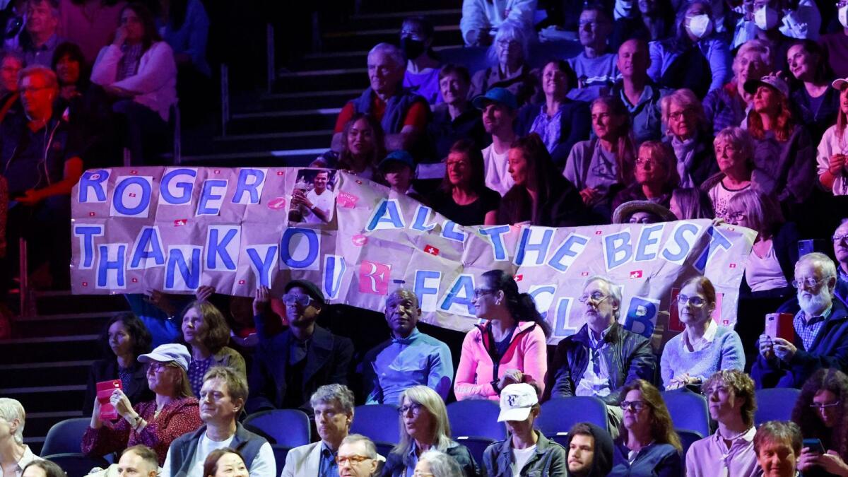 Fans hold a sign for Roger Federer. — Reuters