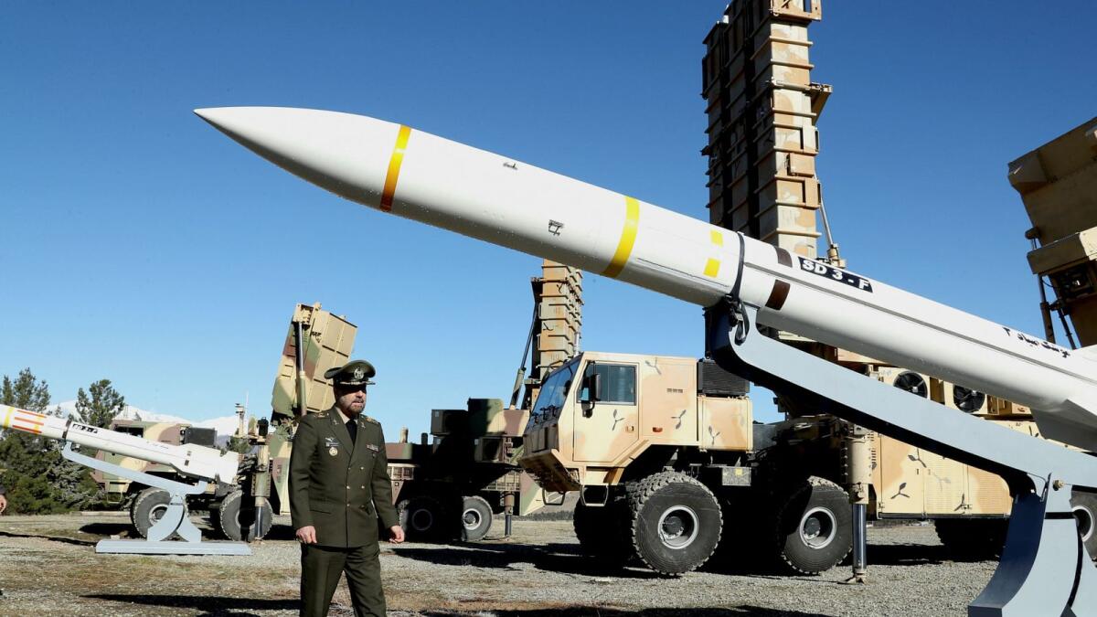 Iran's Defence Minister Brigadier General Mohammad-Reza Ashtiani walks near an Iranian missile during an unveiling ceremony in Tehran. — Reuters