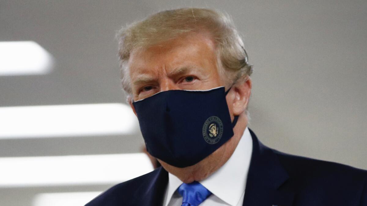 US President Donald Trump wears a face mask as he walks down a hallway during a visit to Walter Reed National Military Medical Center in Bethesda, Md., Saturday, July 11, 2020. Photo: AP