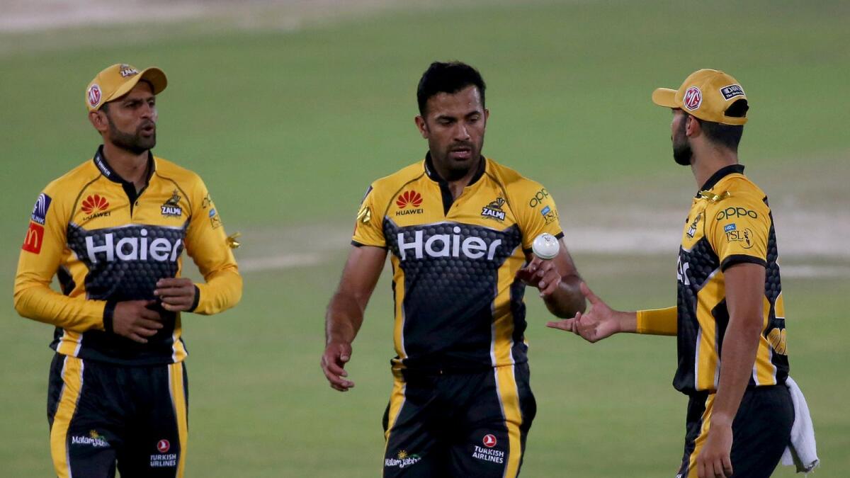 Peshawar Zalmi' Wahab Riaz (centre,) talks to teammates Shoaib Malik (left) and Saqib Mahmood.— AP