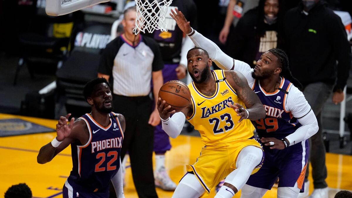 Los Angeles Lakers forward LeBron James (centre) scores past Phoenix Suns forward Jae Crowder (right) during the second half in Game 3 of an NBA basketball first-round playoff series. — AP