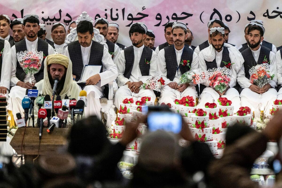 Afghan grooms look on during a mass wedding ceremony at a wedding hall in Kabul on December 25, 2023. — AFP