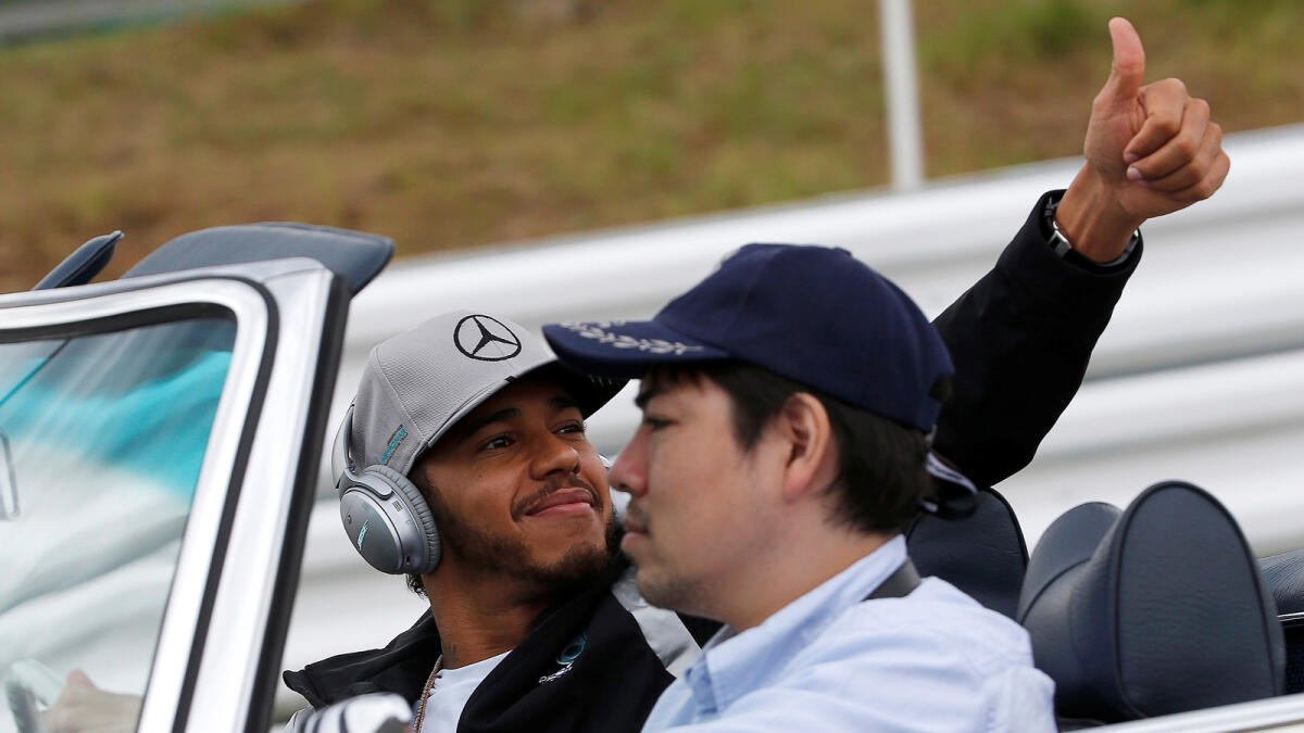 Mercedes' Lewis Hamilton of Britain gestures to fans during the drivers parade. Reuters