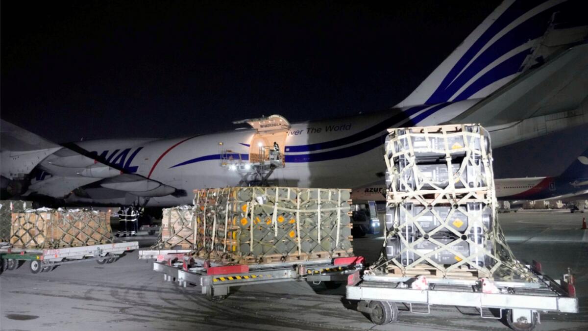 Workers unload a shipment of military aid delivered as part of the United States of America's security assistance to Ukraine, at the Boryspil airport, outside Kyiv. — AP