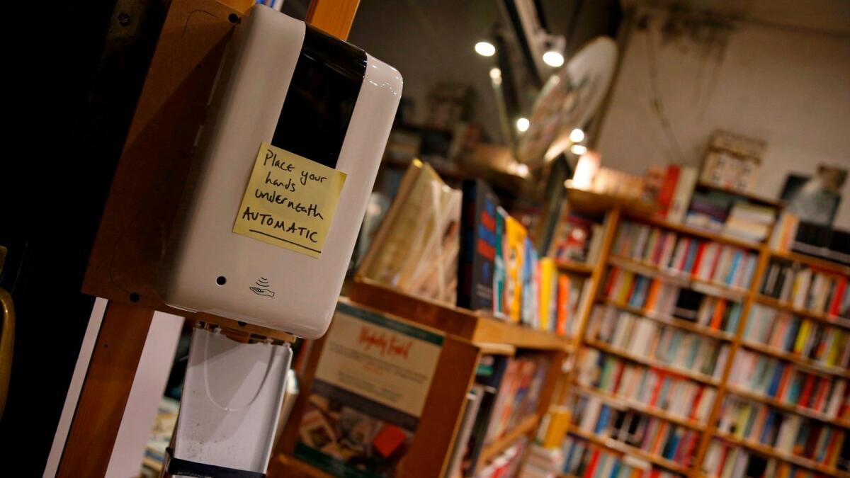 A hand-written note asks customers to use had sanitiser before entering Primrose Hill Books, an independent book shop in west London.