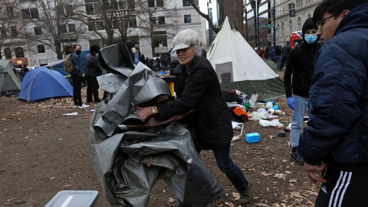 Volunteers help Sharon Brown as she clears away her belongings and her tent, as US Park Service and police clear a homeless encampment at McPherson Square in Washington, US. — Reuters