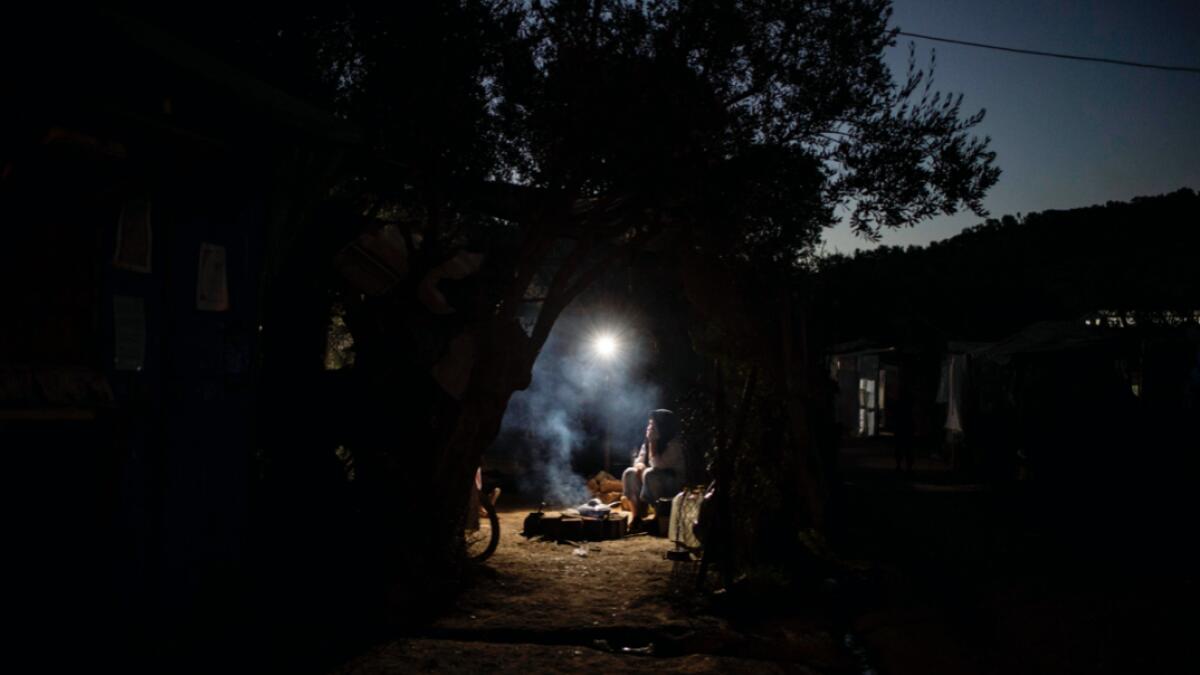 A migrant cook her meal in her tent at the makeshift camp next to the refugee camp of Moria, in the island of Lesbos. Five years ago, the largest camp in Europe, slated to accommodate barely 2,770 people, was contained behind barbed wire. Asylum seekers disembarking on the northern coasts of the island, close to the Turkish shores, were just passing by, the time to register. And Moria was just a stopover on their way to Northern Europe. Photo: AFP