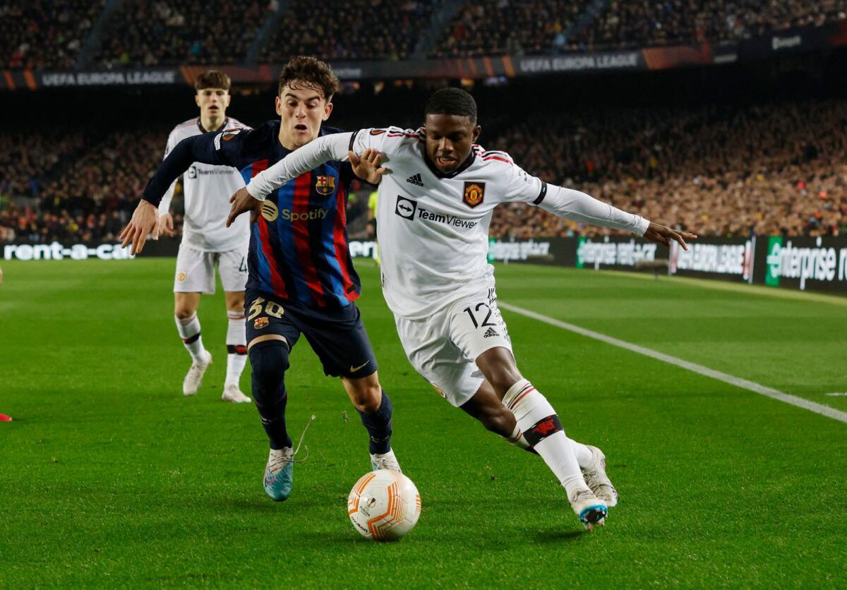 Manchester United's Tyrell Malacia (right) and FC Barcelona's Gavi tussle for the ball. —Reuters