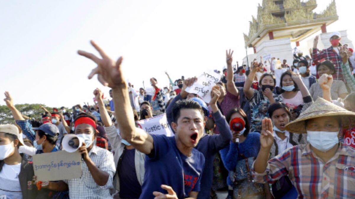 Demonstrators flash a three-fingered symbol of resistance against the military coup. — AP file