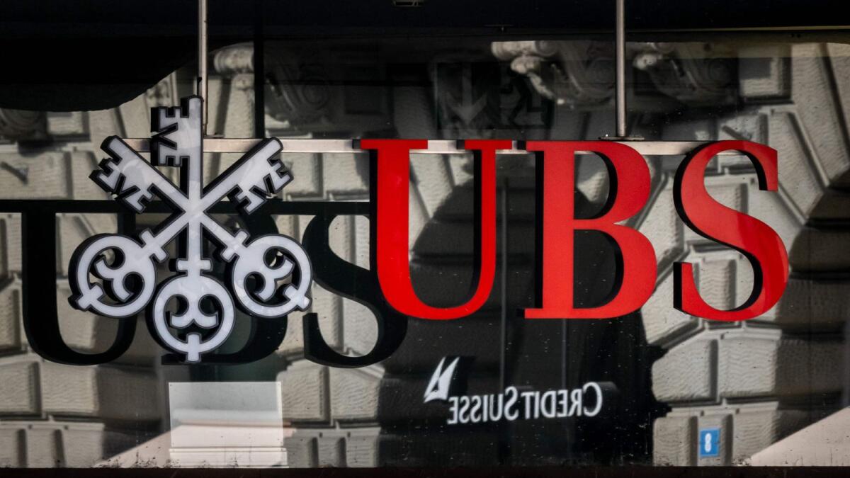 A logo of Swiss giant bank UBS in front of a logo of Credit Suisse bank in Zurich.  The heads of Switzerland's two biggest banks were set for further talks on Sunday, in which UBS could salvage Credit Suisse, which required a $53.7 billion rescue last week over growing doubts about its solvency. - AFP