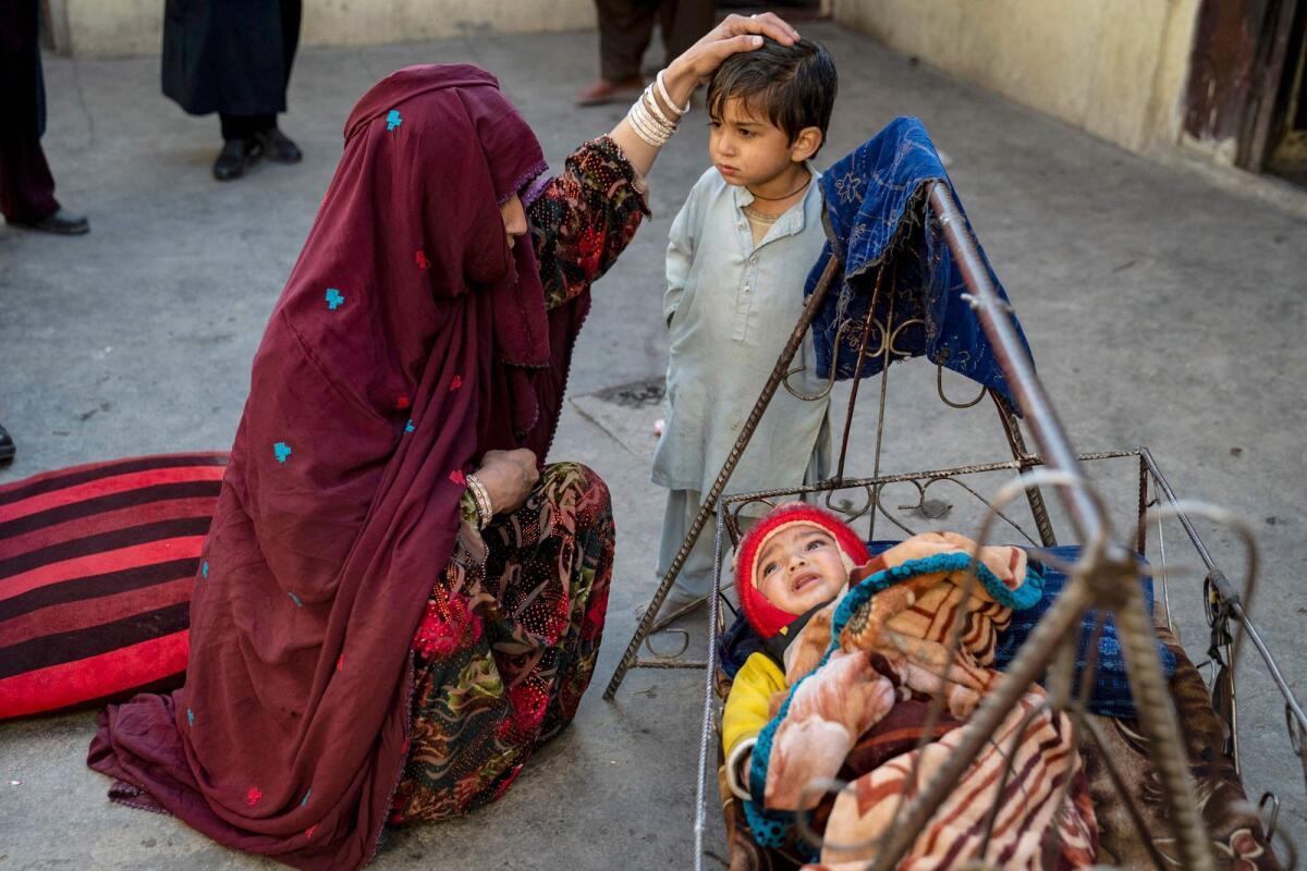 An Afghan woman refugee Najiba, 25, deported from Pakistan, with her son Hasibullah, 5, (C) and daughter Nazia at a house in Bagrami district on the outskirts of Kabul. Najiba arrived in Afghanistan two months ago with her husband and three children. All five sleep on the floor in a room in her brother's house.  — AFP