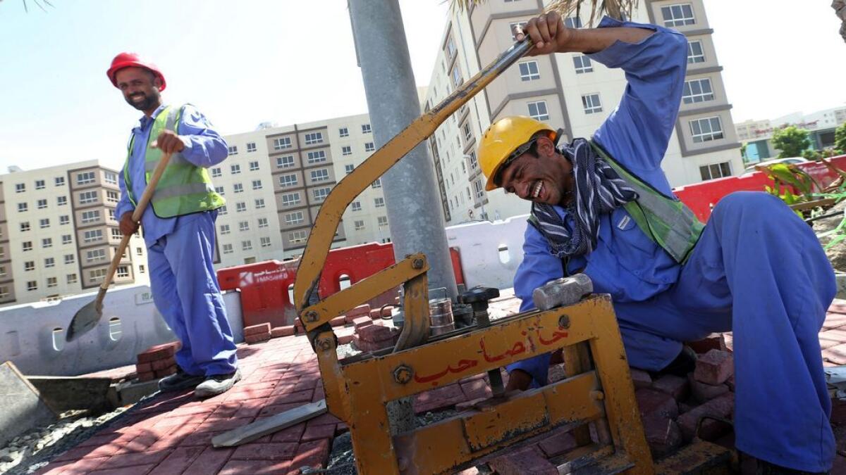 Workers sharing a light hearted moment while working at a construction site in Al Khail Gate in Dubai. 